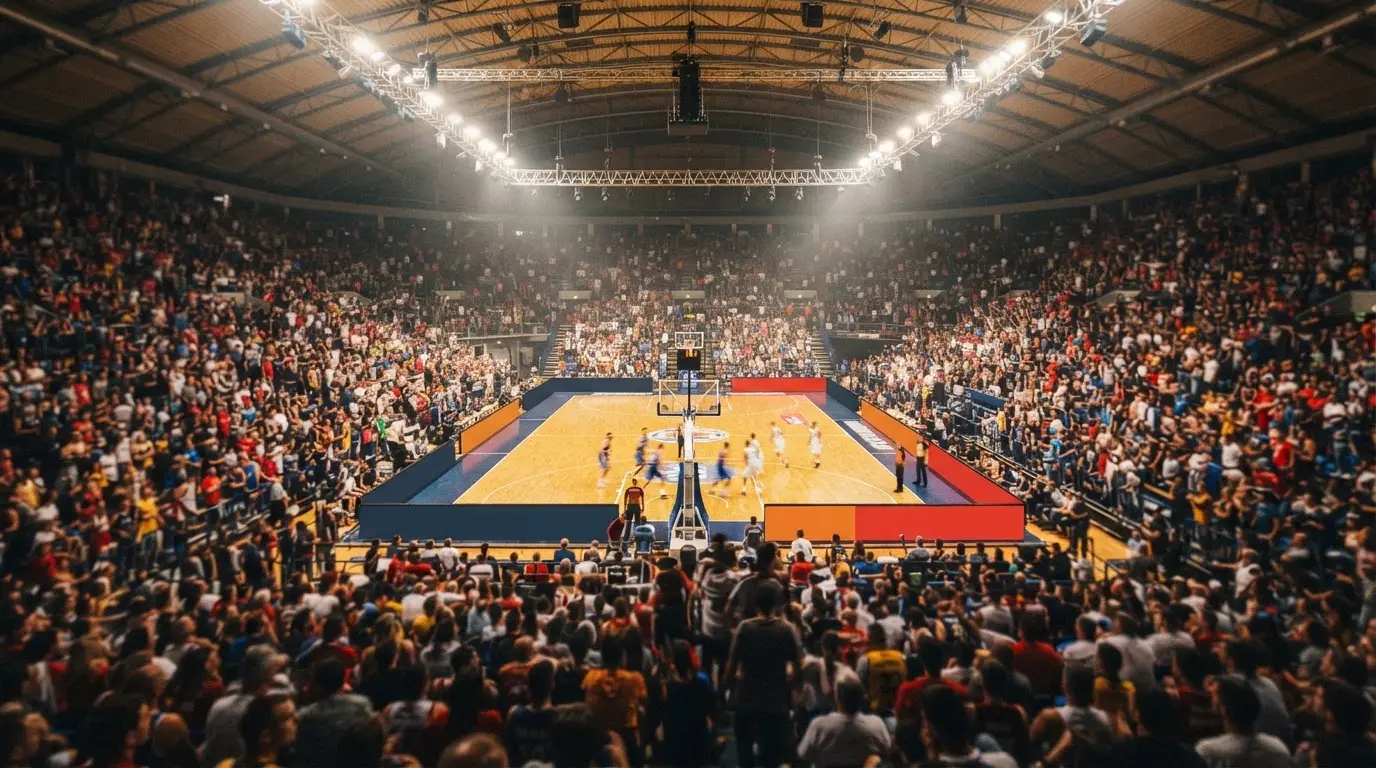 A packed sports hall under floodlights photographed from a long way off