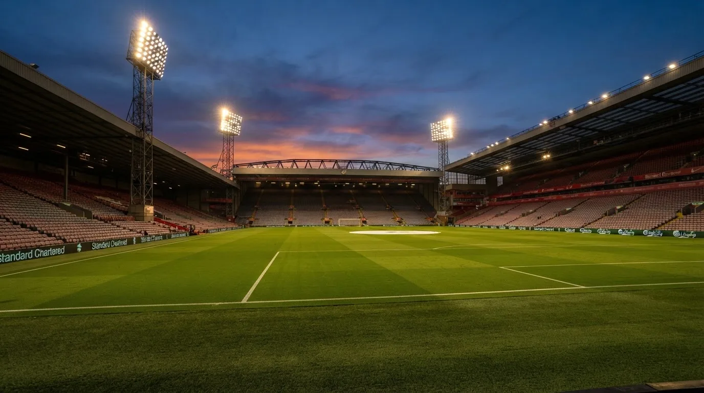 An empty football stadium with floodlight masts at dusk
