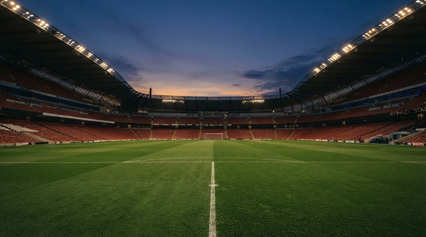 An empty football stadium with floodlight masts at dusk