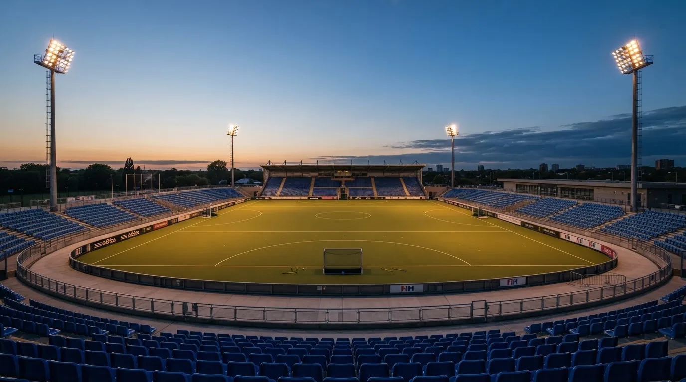 An empty football stadium with floodlight masts at dusk