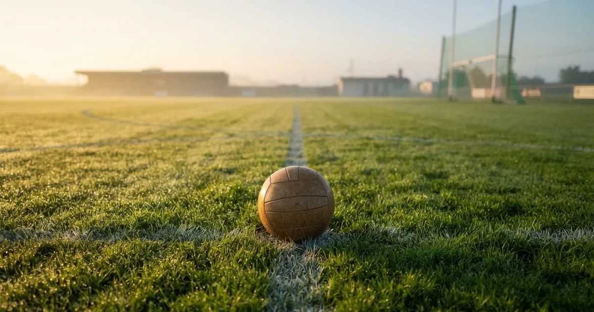 A ball on the centre spot of a grass pitch in morning light