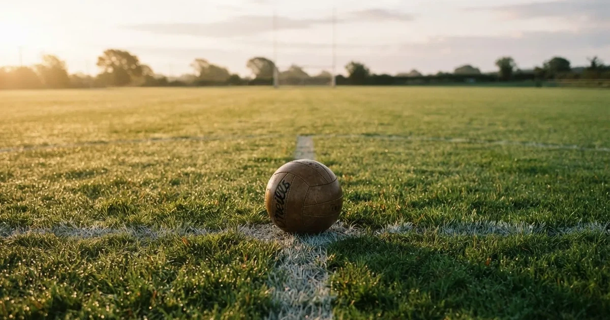 A ball on the centre spot of a grass pitch in morning light